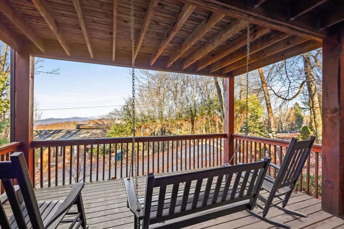 This exterior shot shows wooden swing chairs suspended under sturdy wooden beams, opening to a broad view of surrounding nature. The peaceful atmosphere invites guests to relax, watch wildlife, or unwind with a book, while providing a memorable spot for celebrating special moments or stargazing at night.